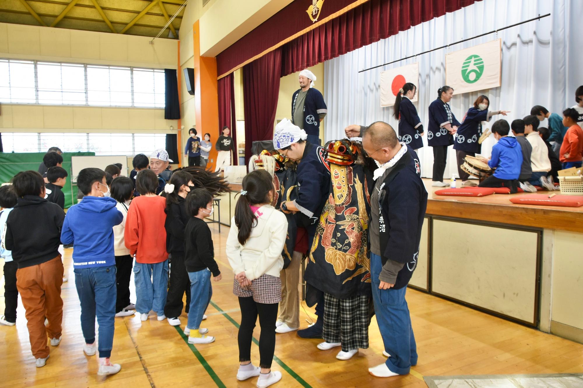 獅子頭をかぶったり、和太鼓を叩いたりする体験