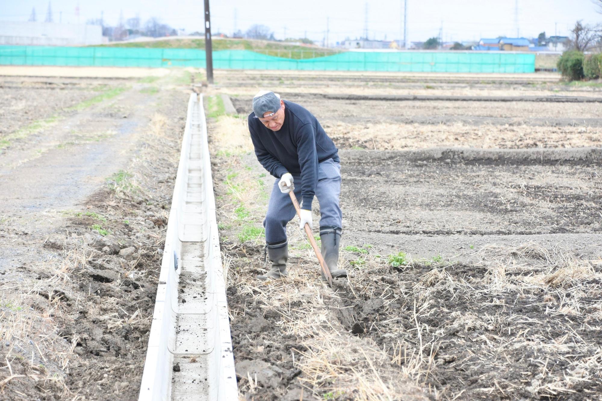 田んぼの土を使って、水路脇を埋め戻す