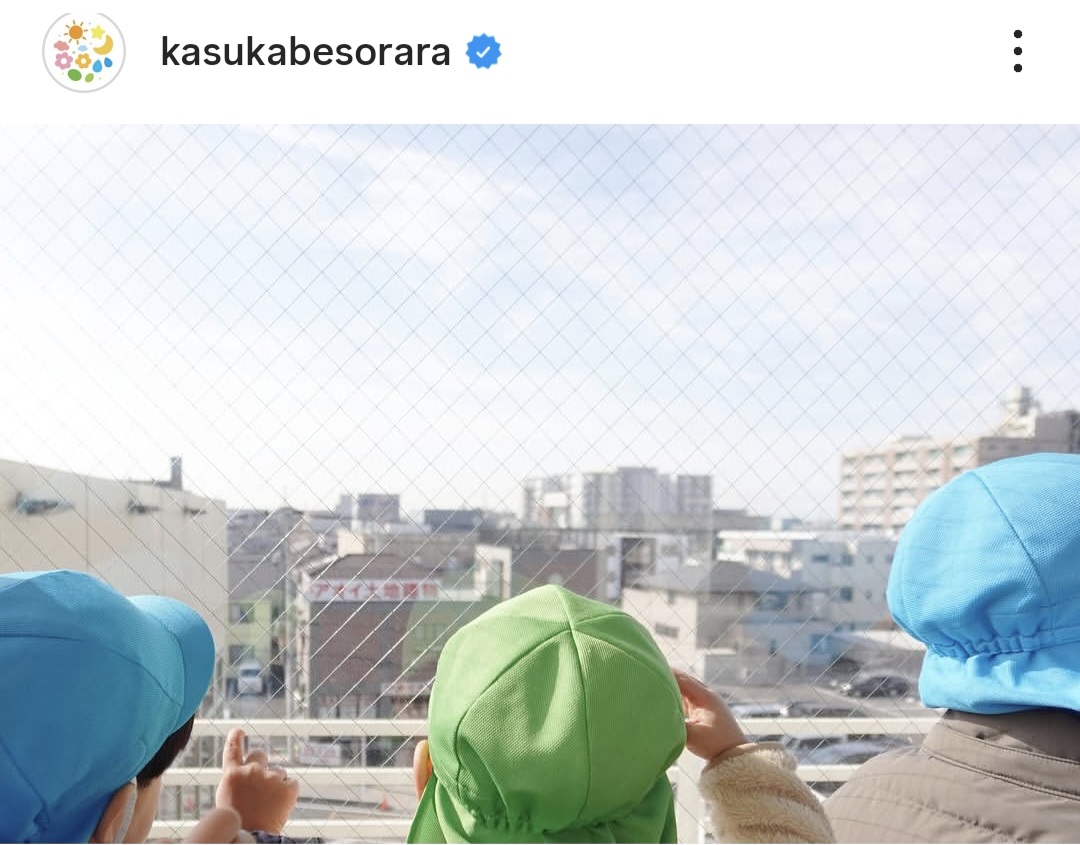 3人のこどもたちが空を指さしている写真