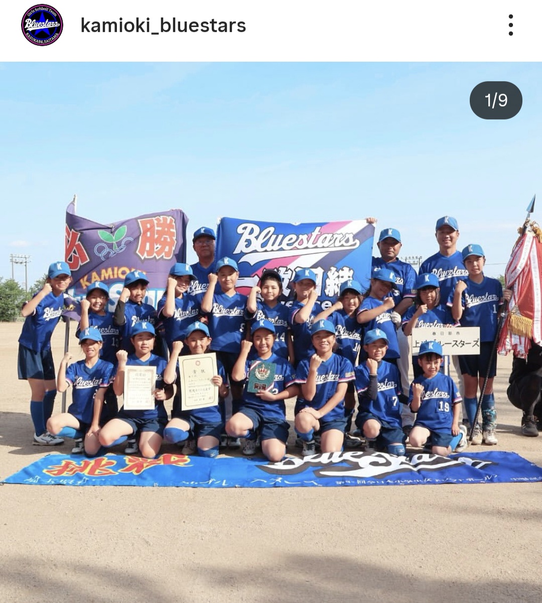 小学生女子ソフトボールチームが賞状を持ってガッツポーズしている写真