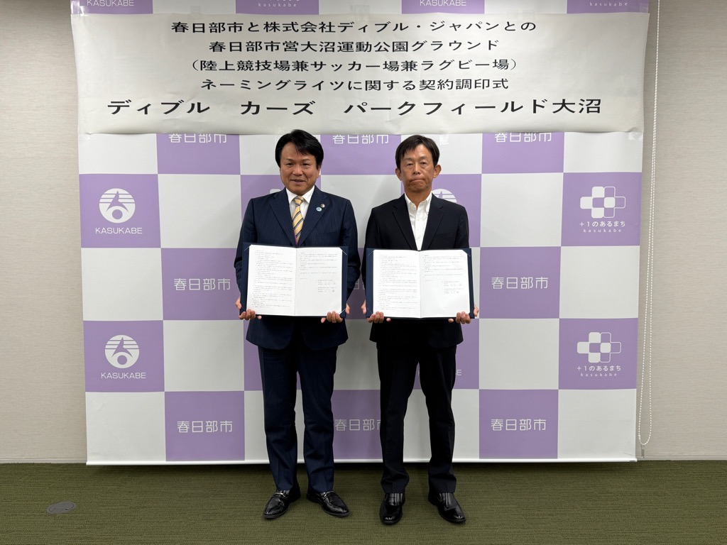 契約書を手に持ち記念撮影する様子