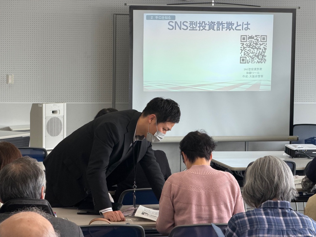 警察官が説明をしながらスマホ操作をお手伝いする様子