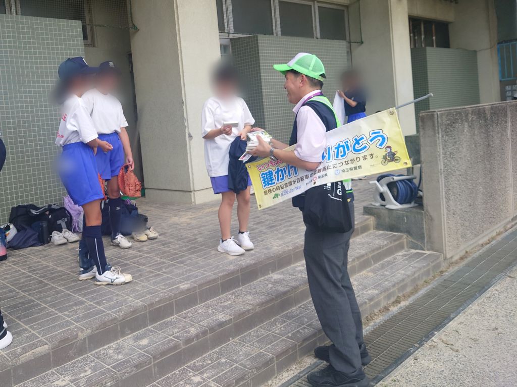 春日部中学校生徒に市役所くらしの安全課職員がカギかけの徹底を呼びかけている様子