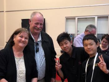 ホームステイの中学生とホストファミリーの笑顔が収められた写真