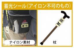 アイロン不可の蓄光シールである本人確認シールを、ナイロン素材のバッグや杖などに貼り付けた様子の写真