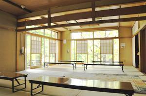 畳敷きの床に折り畳み式の座卓が並ぶ、広間の内装写真