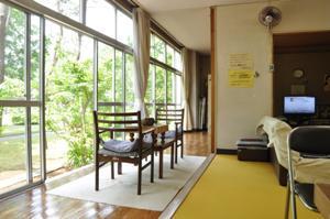 「大枝高齢者憩いの家」の内装の写真。縁側にはテーブルと椅子が配置されているのが確認できる