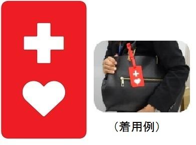十字にハートマークが入ったヘルプマークのイメージと、バッグに付けた着用例を写真で示した説明図