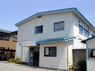 白地の壁に青い屋根の爽やかな印象のリサイクルショップ外観の写真