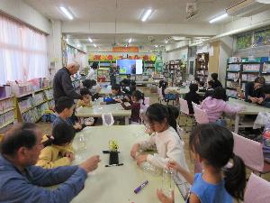 児童がペットボトルを使用した工作をしている写真