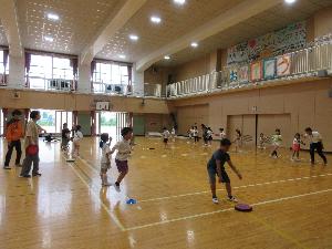 体育館で児童がドッヂビーをしている写真