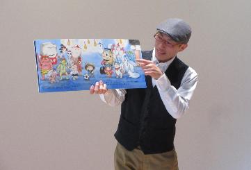 絵本を開いて朗読する読み聞かせ公演会の写真