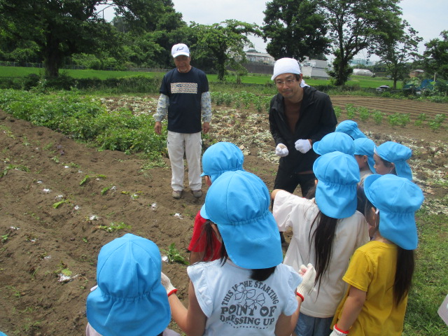 生産者の話を聞いているこども達の様子