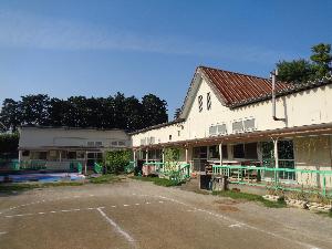 藤塚香取神社に隣接する赤茶色の瓦屋根が特徴的な春日部市立第5保育所の外観をグラウンド側から撮影した写真
