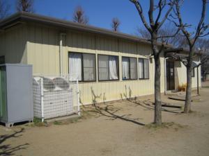 八木崎小学校内にある枯れ木に囲まれた八木崎放課後児童クラブ1および2の外観を左斜め側から撮影した写真