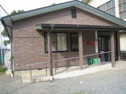 三角屋根で茶色い外壁の平屋建ての建物の緑放課後児童クラブの外観の写真