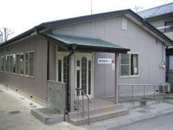 緑色の三角屋根にピンク色の外壁の南桜井放課後児童クラブの外観の写真