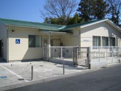 車椅子マーク付きの駐車場も完備された緑色の屋根が特徴的な武里小学校内にある武里放課後児童クラブの外観を撮影した写真