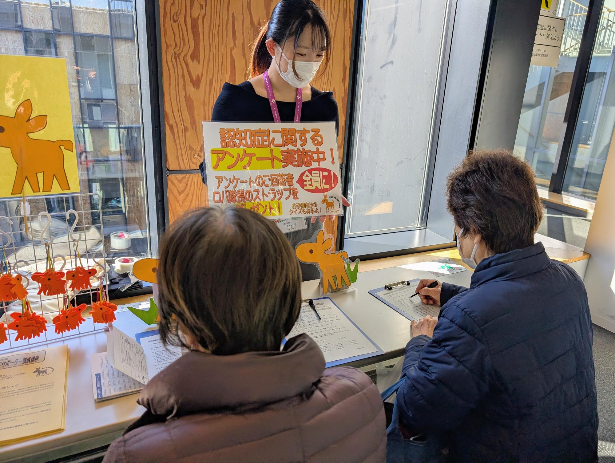 健康フェアにて認知症に関するアンケート調査を記入している参加者の様子