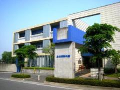 青いパーツのある看板と、大きな建物が奥に見える、春日部市第4地域包括支援センターの外観の写真