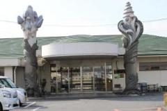 入り口の両脇に変わった形のモニュメントが立っている、春日部市第8地域包括支援センターの外観の写真