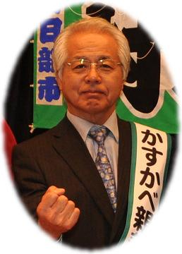 右手でガッツポーズをするスーツ姿の増村紀一郎氏の写真