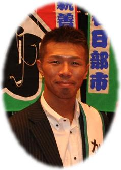 白いボタンダウンシャツにブレザー姿でほほ笑む内山高志氏の写真