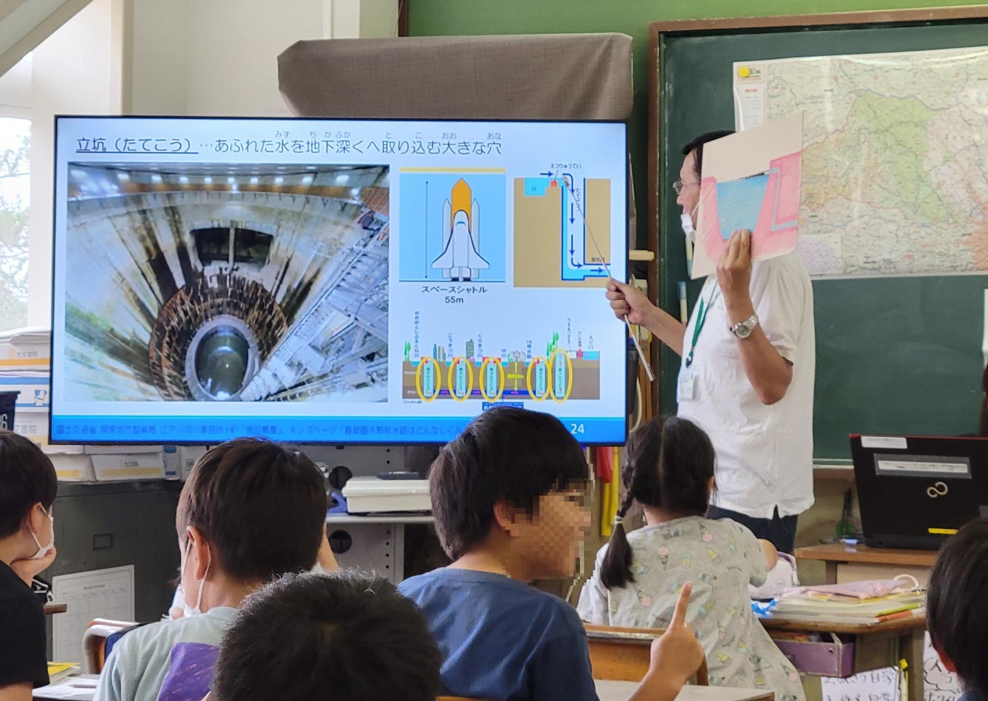 外郭放水路の仕組みについて説明する様子