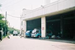 青色の収集車が二台留まっているクリーンセンター外観写真