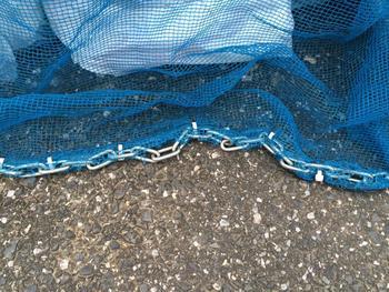 防鳥ネットの端に、重しとして鎖が取り付けられている写真