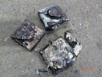 黒く焦げた物体が3つ並んでいる、リチウムイオン電池により発火したものの写真