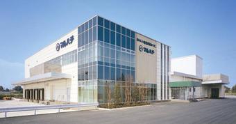 青空の下で広い敷地に建つ株式会社マルハチの建物の写真