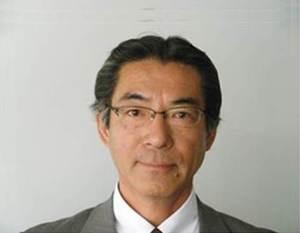 グレーのスーツを身に着けた代表取締役 平岡 英介（ひらおか えいすけ）様の写真