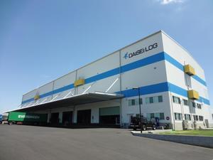 白と水色を基調とした、所々にユニークな四角く黄色いでっぱりのあるダイセーロジスティクスの建物の写真