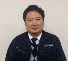 作業服のジャケットを着た玉俊工業所長 鬼島 務（きじま つとむ）様の写真