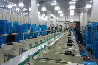 ベルトコンベアーとたくさんの箱が並ぶ作業風景の写真