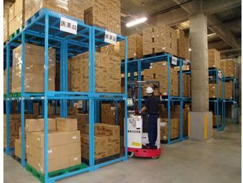 フォークリフトを使って荷物の上げ下ろしを行う倉庫での作業風景の写真