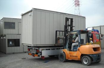 フォークリフト車とトラックが並んでいる作業風景の写真