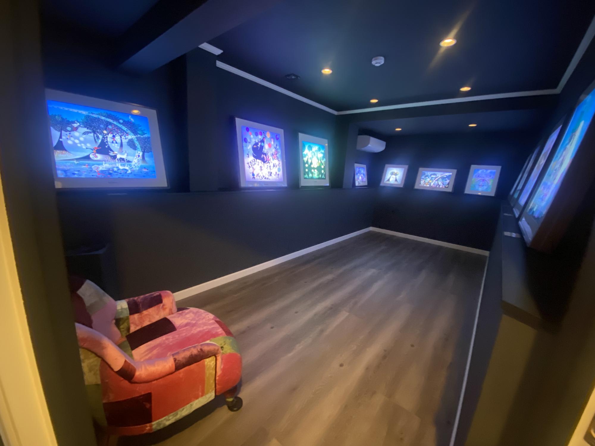 暗闇の中光る作品が特徴的な展示とソファの写真