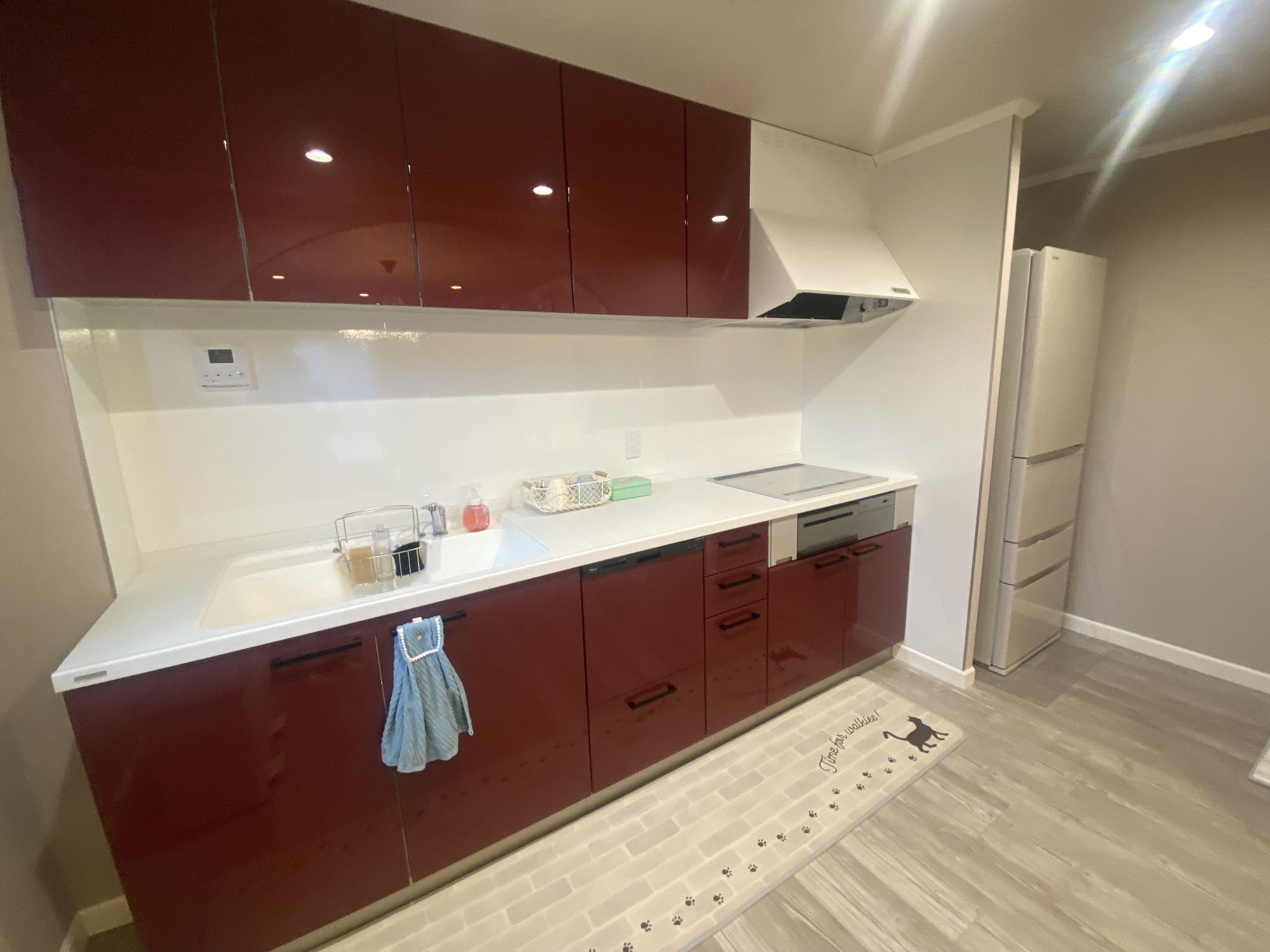 えんじ色と白を基調としたキッチンの写真