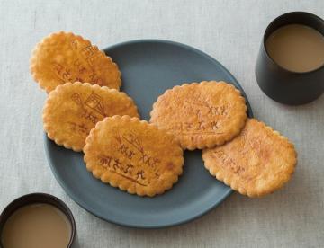 黒い素焼きのお皿に載せられている春日部大凧さぶれの写真