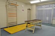 雲梯や体育マット、小型のビリヤード台などの機能回復訓練器具が用意されている部屋の写真