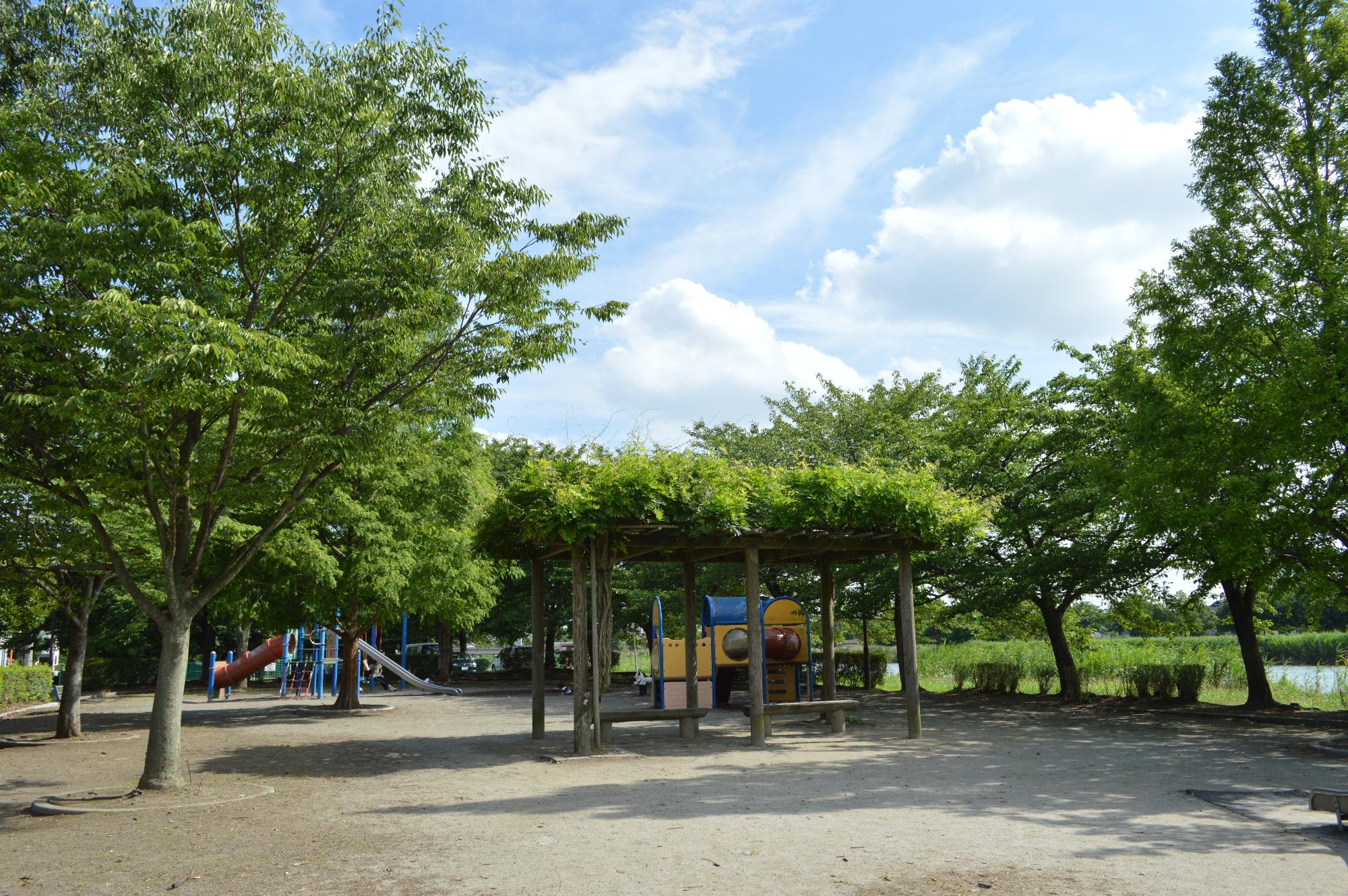 木々に遊具が囲まれている牛島古川公園の写真