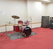 赤いじゅうたんの上に立つドラムセットの写真