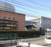 温かみのあるレンガ風の建物と近代的なコンクリート造りの建物が通路でつながっている写真