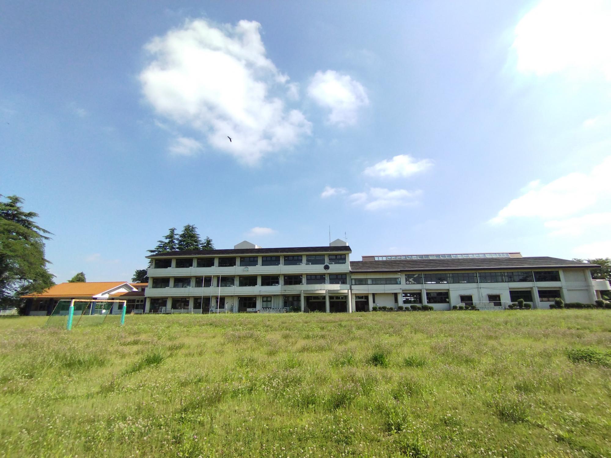 ハルカイト外観。小学校の面影が残る姿、校庭には緑が多く見える