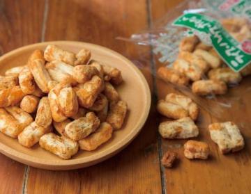 木彫りの皿に乗せて提供されているなべちゃんの網焼あられの写真