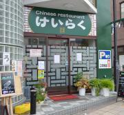 緑で統一された建物と看板が特徴的なけいらく外観の写真