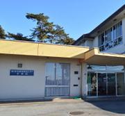 背の低い建物から通路を通じて二階建ての建物につながっている施設の写真