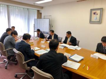 木製の机に向かい合い話し合う第3回協議会の写真